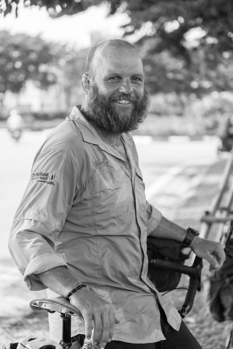 Ron Rutland leaning on his bicycle, black and white